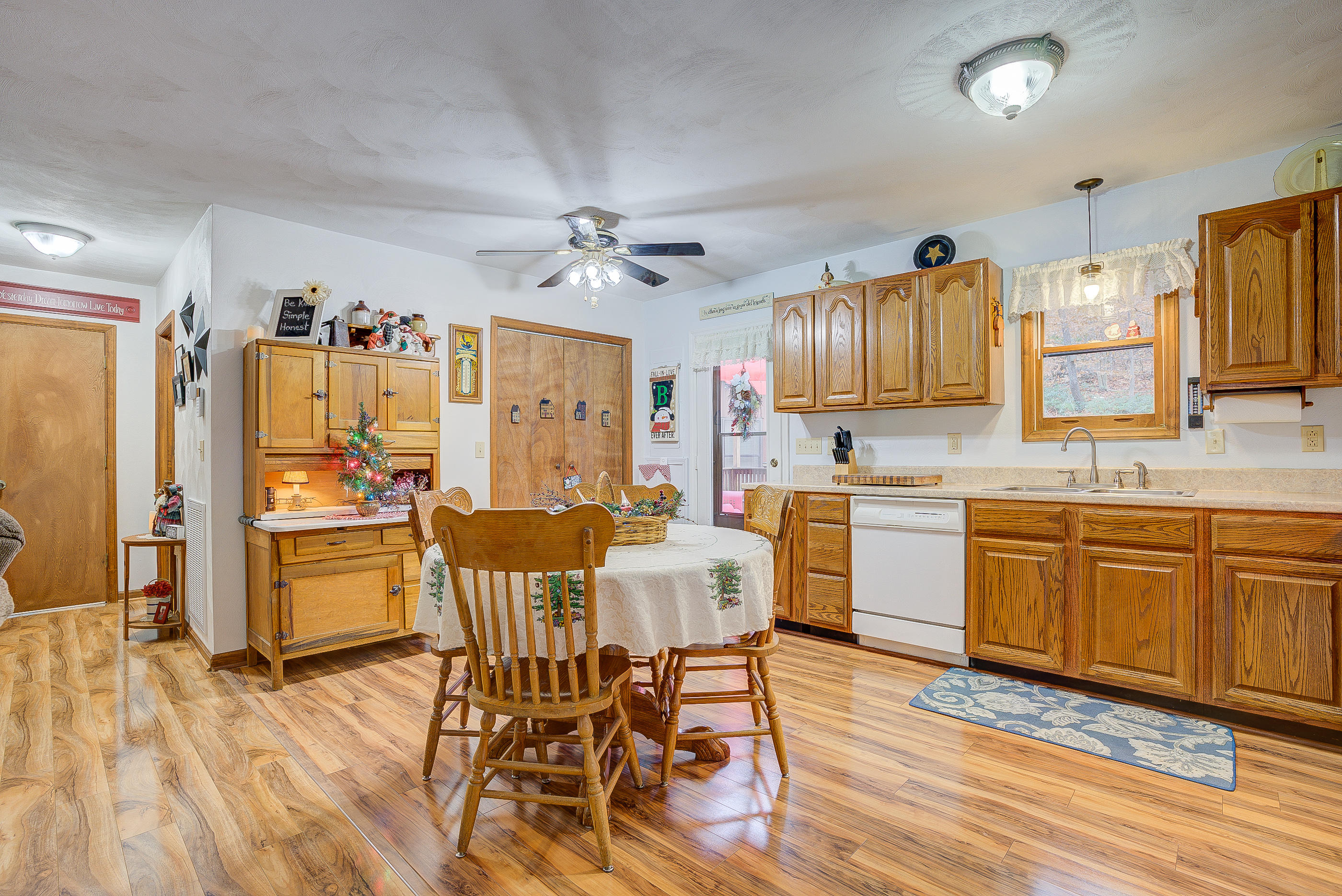 1037 Buck Mountain Road Goodview, VA 24095 - Photo 17 of 31 a kitchen with stainless steel appliances kitchen island granite countertop a refrigerator a stove a sink dishwasher with a dining table and chairs with wooden floor
