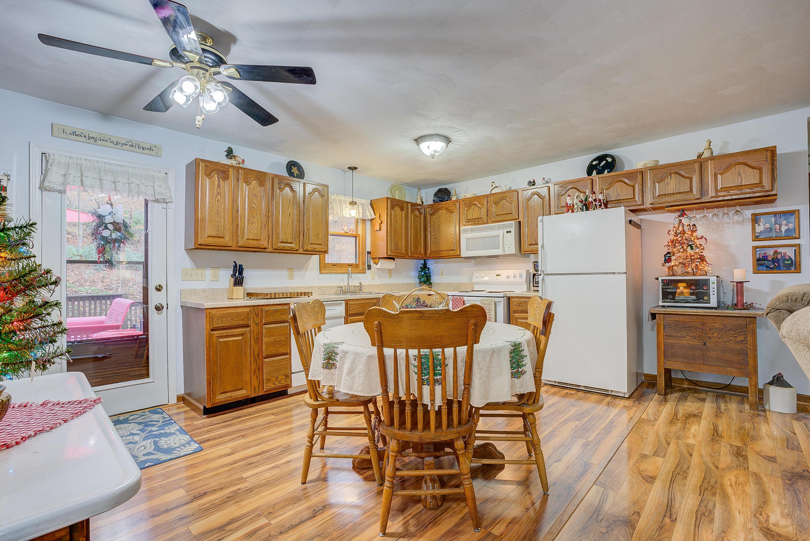 1037 Buck Mountain Road Goodview, VA 24095 - Photo 18 of 31 a kitchen with stainless steel appliances kitchen island granite countertop a refrigerator a stove a microwave oven with a dining table and chairs with wooden floor