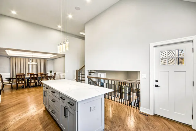 a kitchen with a stove a refrigerator and a dining table with wooden floor
