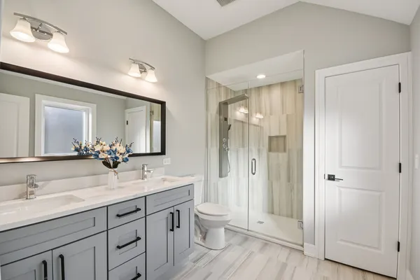 a spacious bathroom with a double vanity sink mirror and toilet