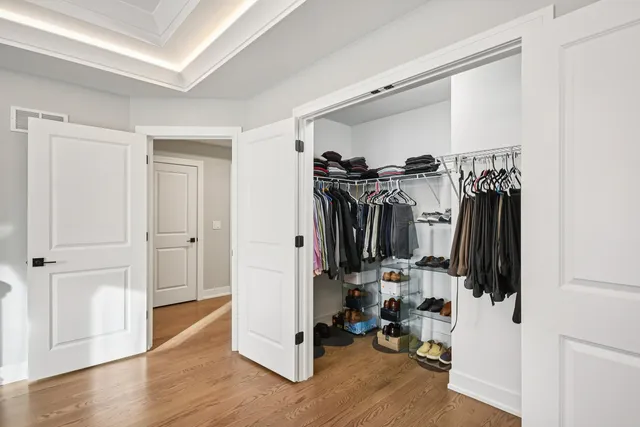 a view of walk in closet with clothes and shoes