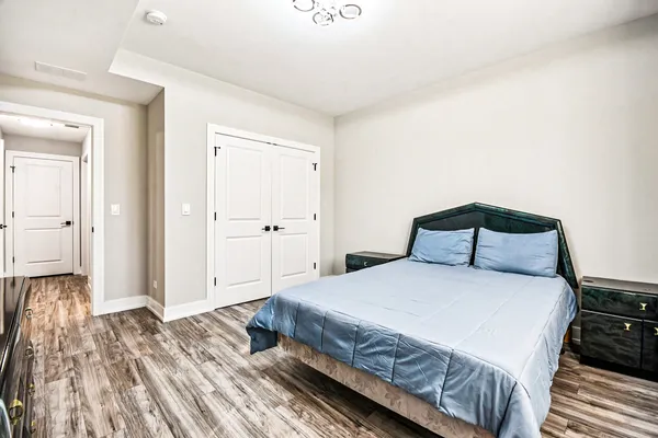 a bedroom with a bed and wooden floor