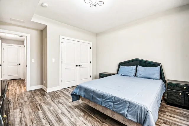 a bedroom with a bed and wooden floor