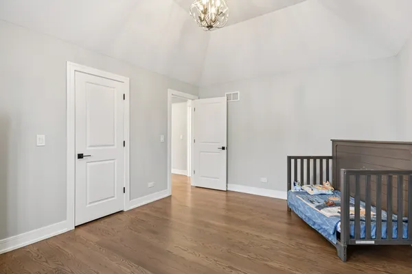 a spacious bedroom with a bed and a chandelier