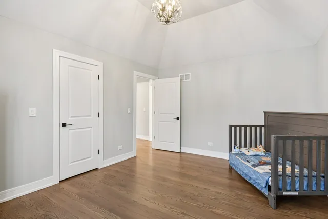 a spacious bedroom with a bed and a chandelier