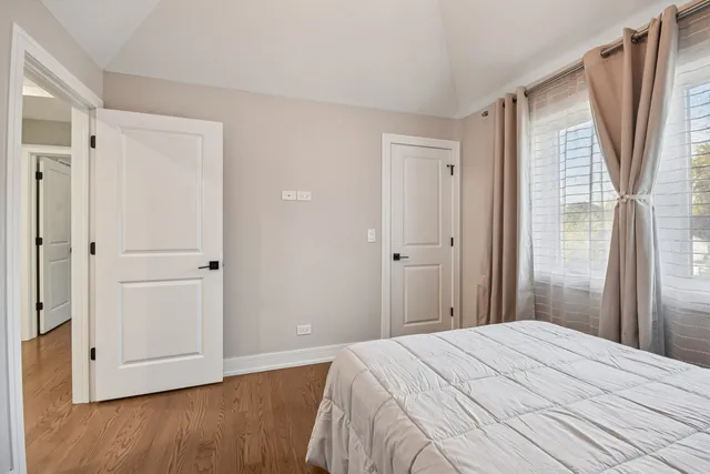 a bedroom with a bed and wooden floor