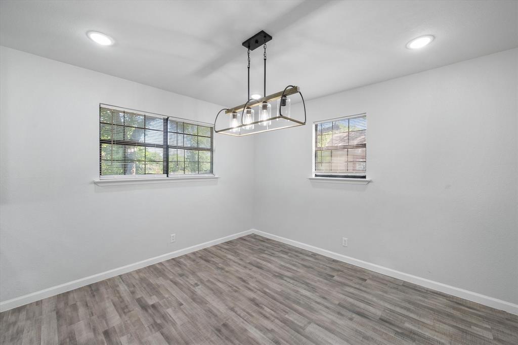 1312 East Collin Street Corsicana, TX 75110 - Photo 12 of 24 an empty room with wooden floor windows and ceiling fan