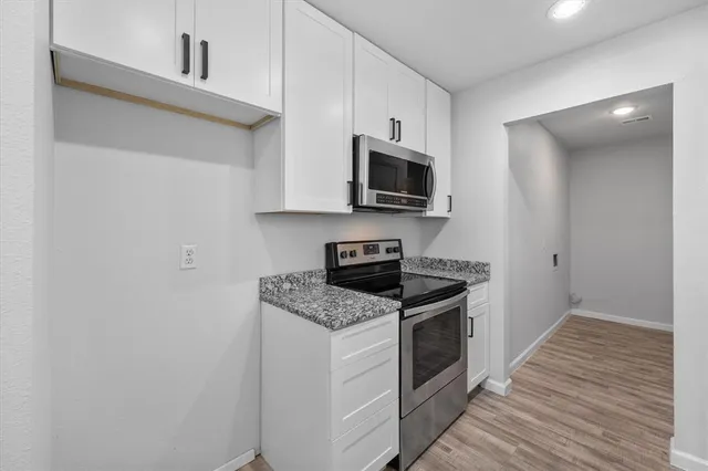 a kitchen with granite countertop a stove top oven and sink