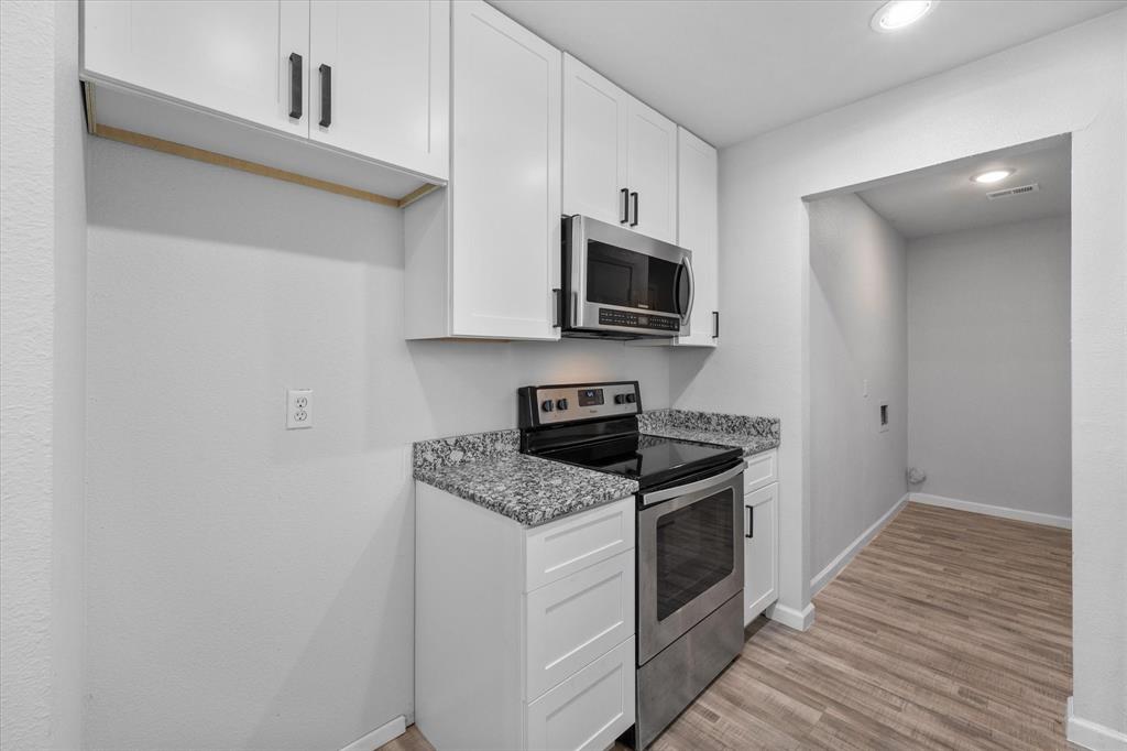 1312 East Collin Street Corsicana, TX 75110 - Photo 14 of 24 a kitchen with granite countertop a stove top oven and sink