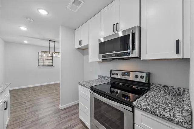 a kitchen with stainless steel appliances granite countertop a stove a microwave and cabinets