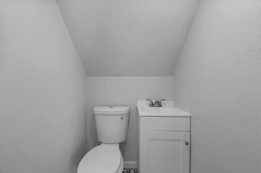 1312 East Collin Street Corsicana, TX 75110 - Photo 17 of 24 a bathroom with a sink mirror and toilet