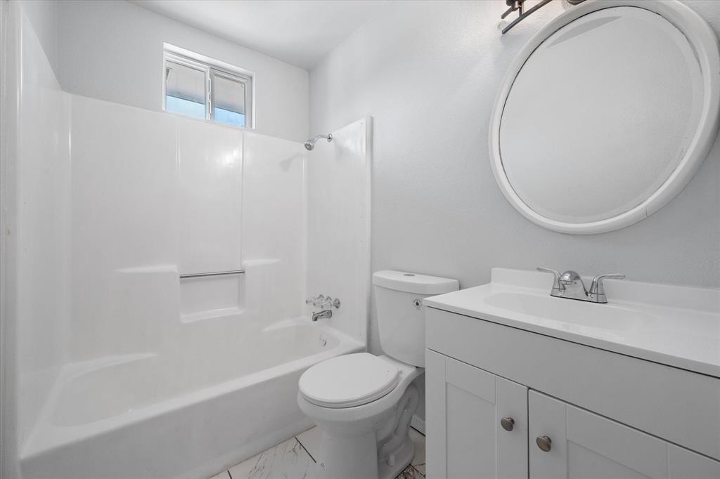 1312 East Collin Street Corsicana, TX 75110 - Photo 20 of 24 a bathroom with a sink a toilet and a mirror
