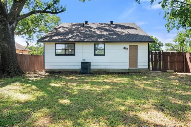 a view of a house with backyard and tree