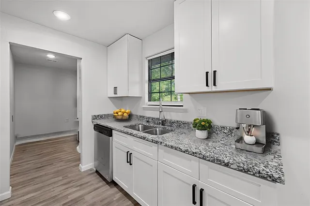 a kitchen with sink a window and cabinets
