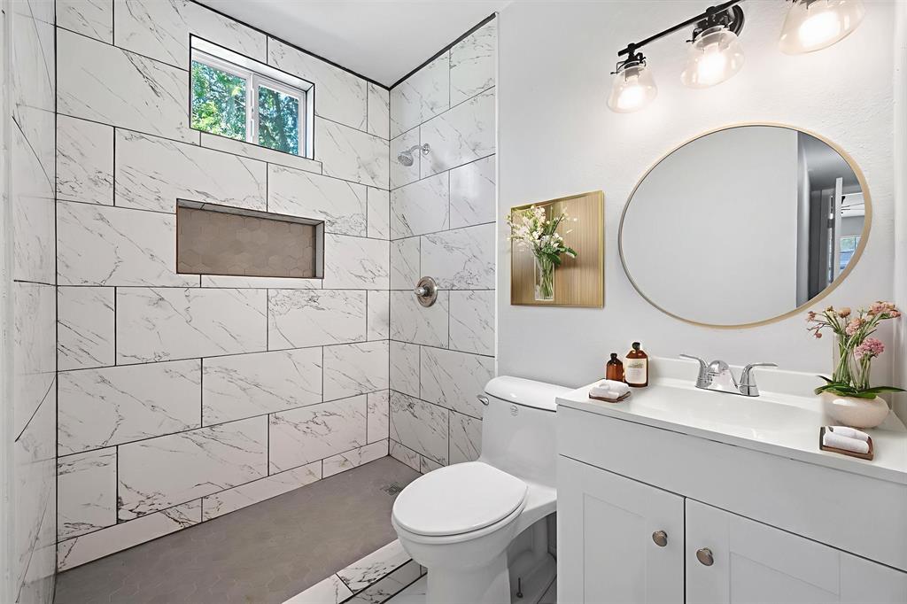 1312 East Collin Street Corsicana, TX 75110 - Photo 5 of 24 a bathroom with a toilet sink and mirror
