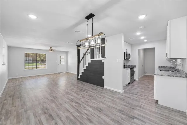 a view of a kitchen with refrigerator and wooden floor
