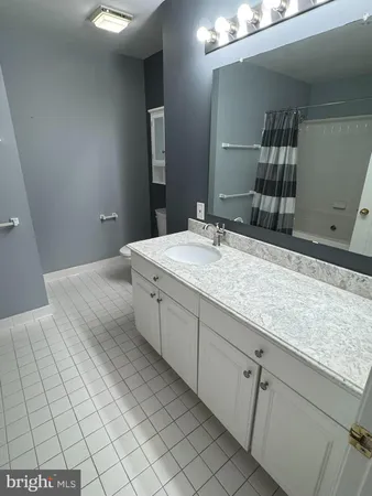 a spacious bathroom with a granite countertop sink and a mirror