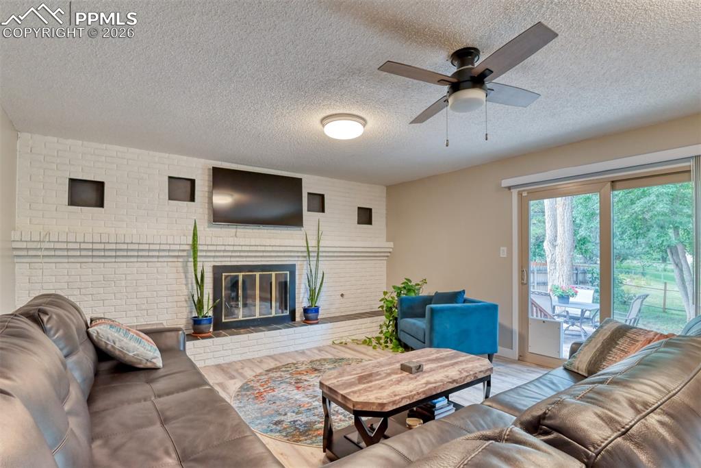 4506 Ridgecrest Drive Colorado Springs, CO 80918 - Photo 16 of 49 a living room with furniture a fireplace and a flat screen tv