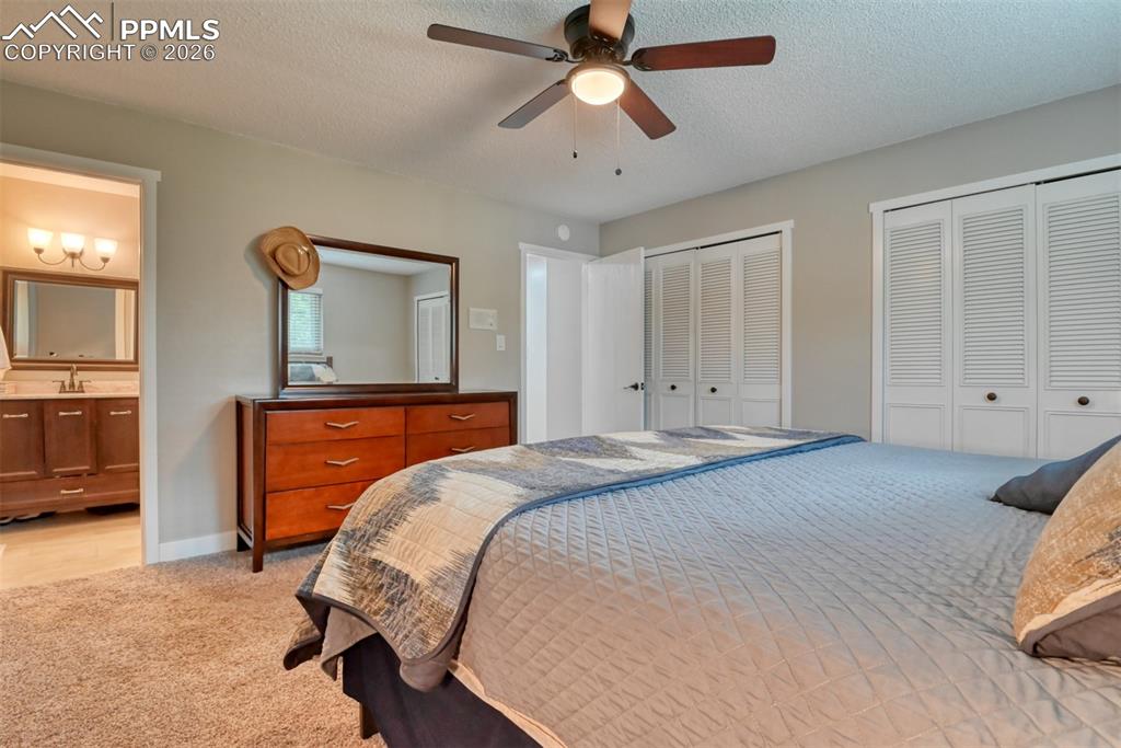 4506 Ridgecrest Drive Colorado Springs, CO 80918 - Photo 19 of 49 a bedroom with a bed and a chandelier