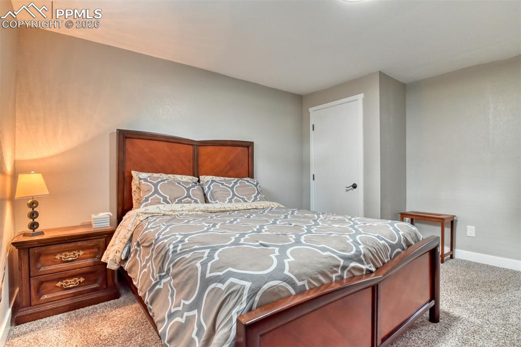 4506 Ridgecrest Drive Colorado Springs, CO 80918 - Photo 34 of 49 a bedroom with a bed and a lamp with the bathroom
