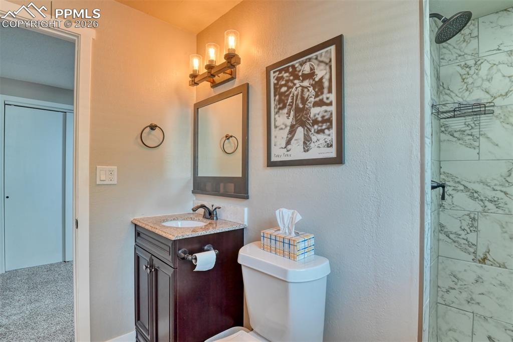 4506 Ridgecrest Drive Colorado Springs, CO 80918 - Photo 36 of 49 a bathroom with a toilet sink and mirror