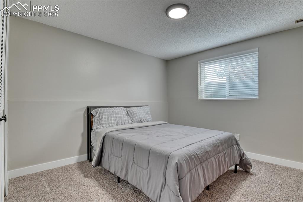 4506 Ridgecrest Drive Colorado Springs, CO 80918 - Photo 37 of 49 a bedroom with a bed and window