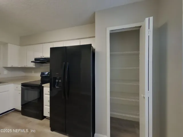 a kitchen with a refrigerator and cabinets