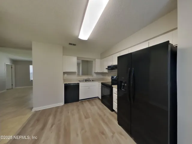 a kitchen with a refrigerator and a sink