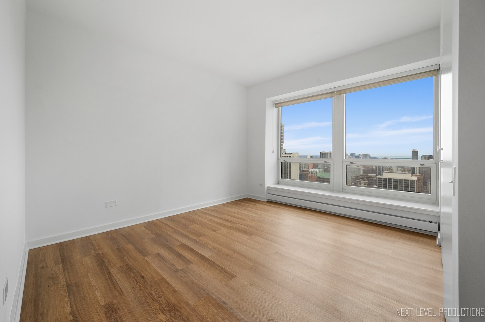 57 East Delaware Place, Unit 3203 Chicago, IL 60611 - Photo 12 of 27 a view of a big room with wooden floor and windows