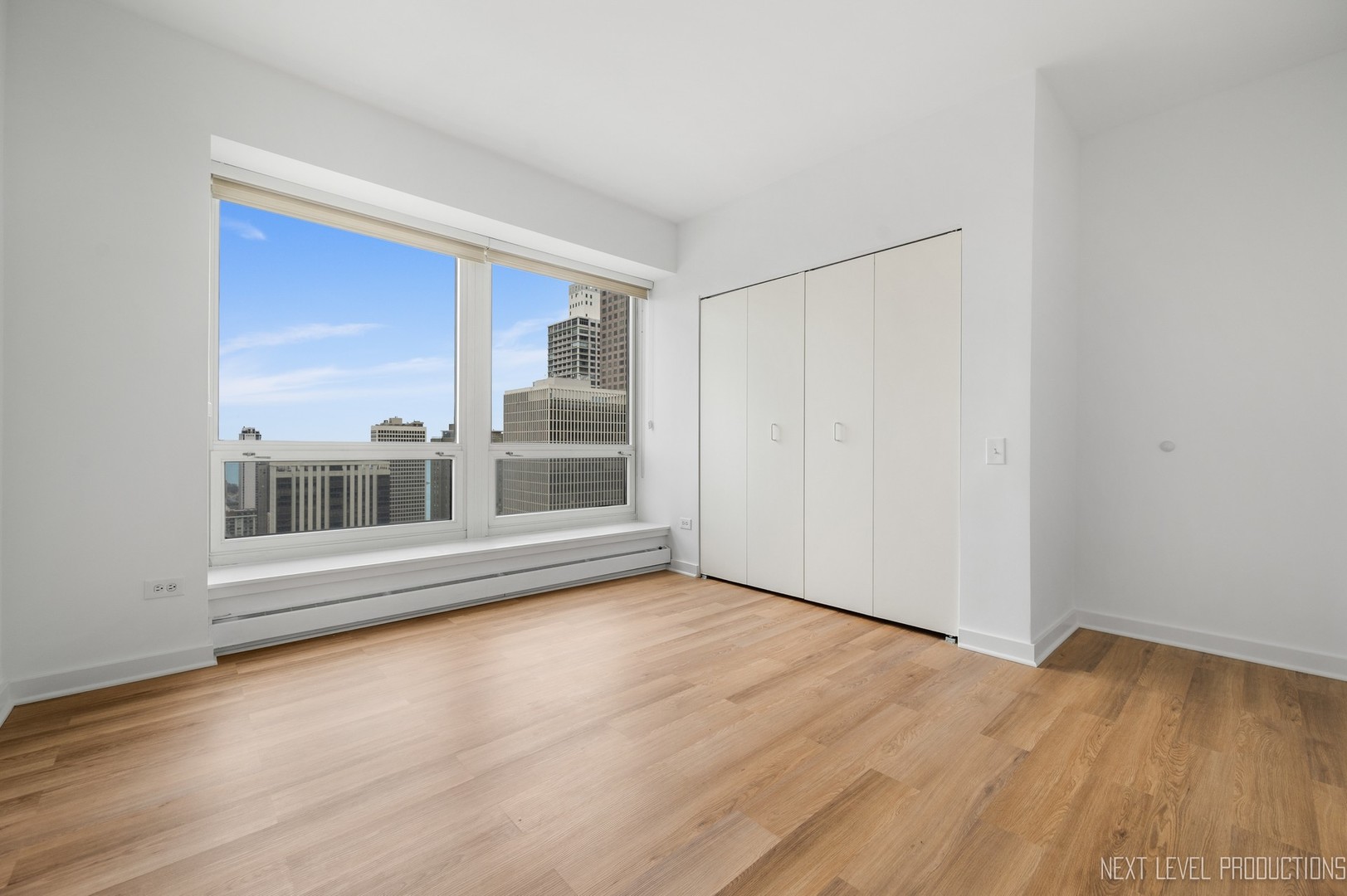 57 East Delaware Place, Unit 3203 Chicago, IL 60611 - Photo 13 of 27 an empty room with wooden floor and windows