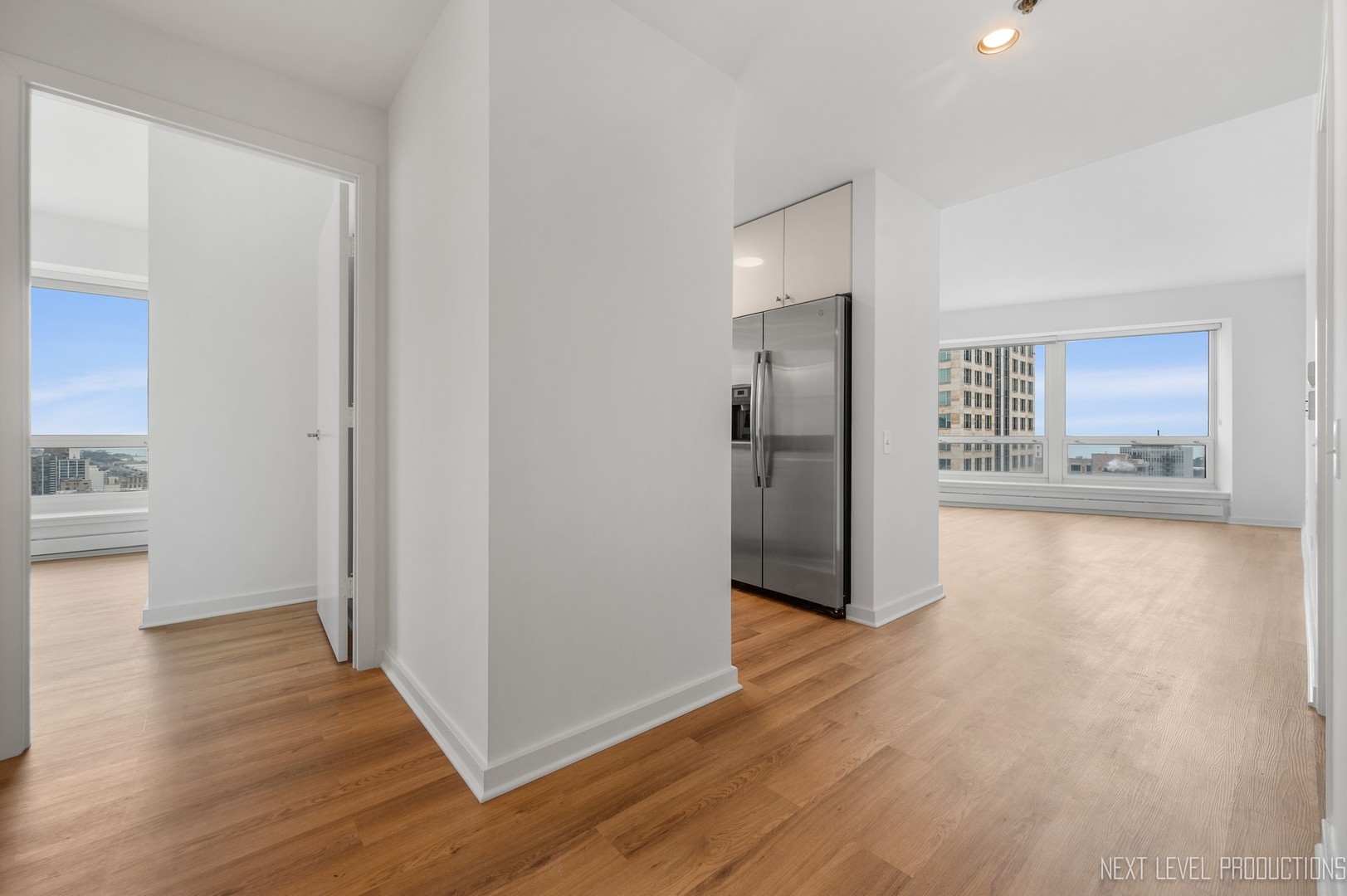 57 East Delaware Place, Unit 3203 Chicago, IL 60611 - Photo 3 of 27 a view of a kitchen with wooden floor and a refrigerator