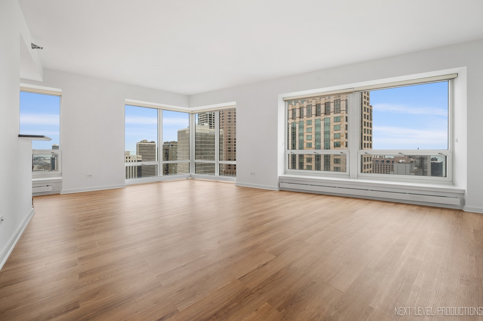 57 East Delaware Place, Unit 3203 Chicago, IL 60611 - Photo 5 of 27 wooden floor in an empty room with a window