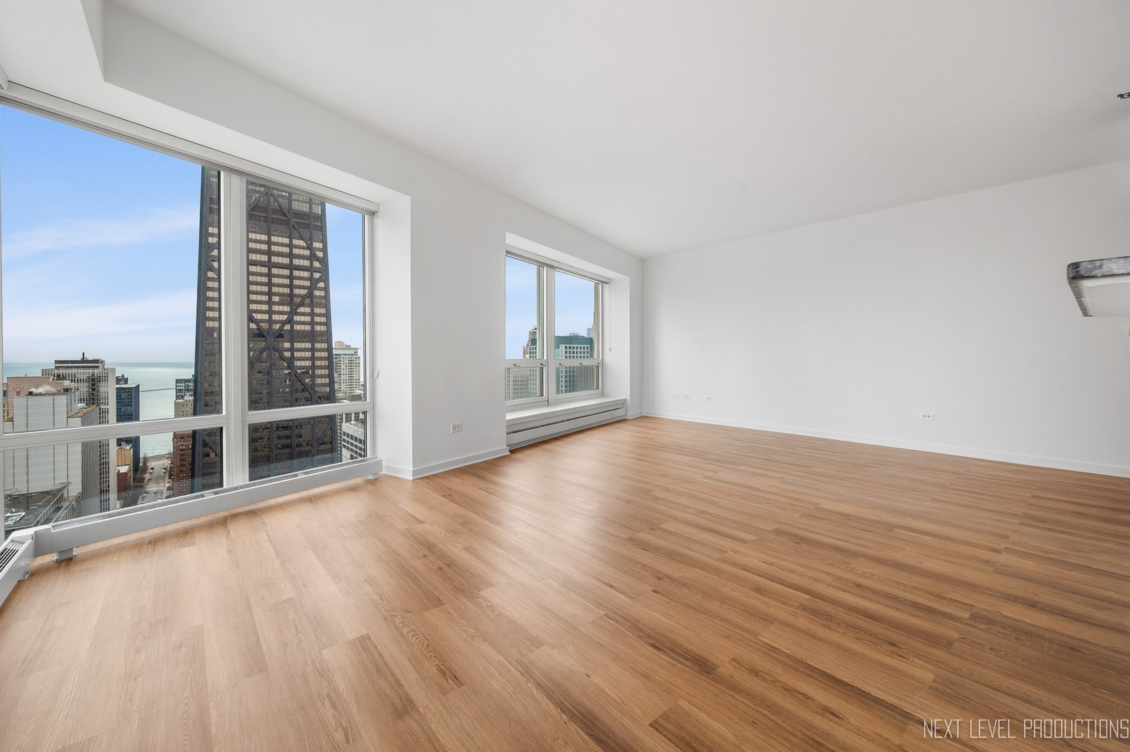 57 East Delaware Place, Unit 3203 Chicago, IL 60611 - Photo 6 of 27 a view of an empty room with wooden floor and a window