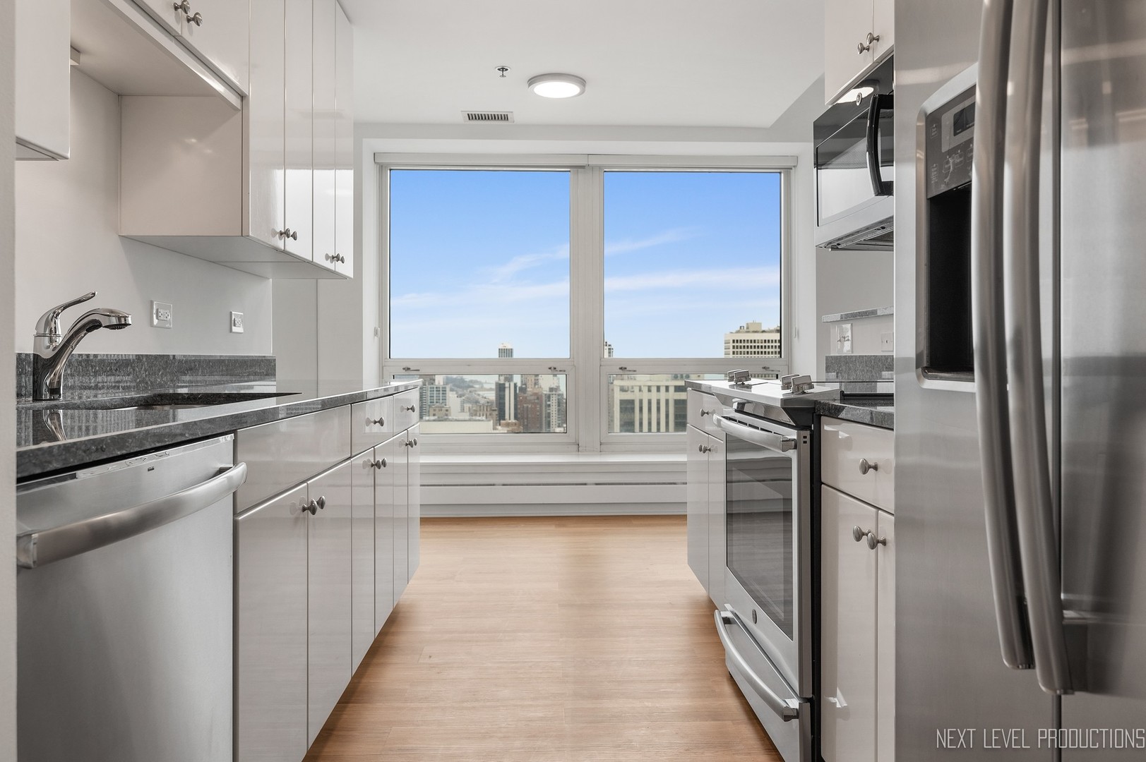 57 East Delaware Place, Unit 3203 Chicago, IL 60611 - Photo 9 of 27 a kitchen with stainless steel appliances a refrigerator sink and cabinets