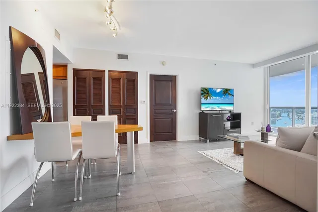 a bedroom with a bed and a flat tv screen on dresser