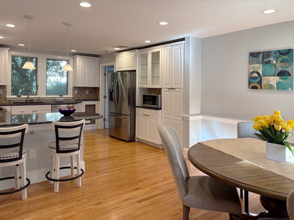 50 Dwhinda Road Newton, MA 02468 - Photo 17 of 42 a kitchen with granite countertop a refrigerator a stove a sink and a dining table with wooden floor