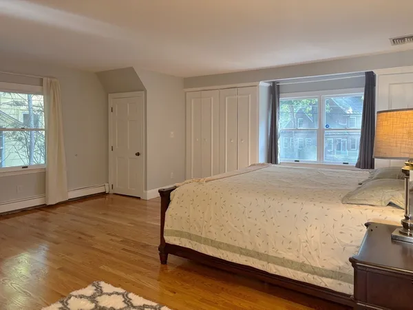 a bed sitting in a spacious bedroom next to a window