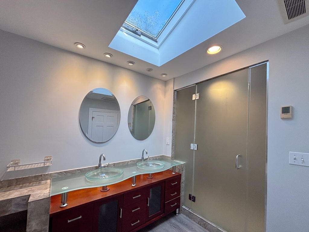 50 Dwhinda Road Newton, MA 02468 - Photo 25 of 42 a bathroom with a double vanity sink and a mirror