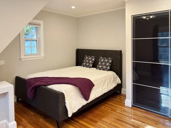 a large bed sitting in a bedroom next to a window and a mirror