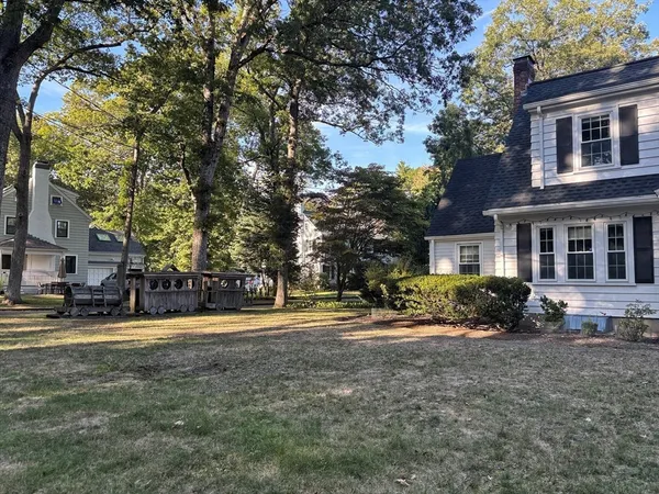 a front view of a house with a yard and trees