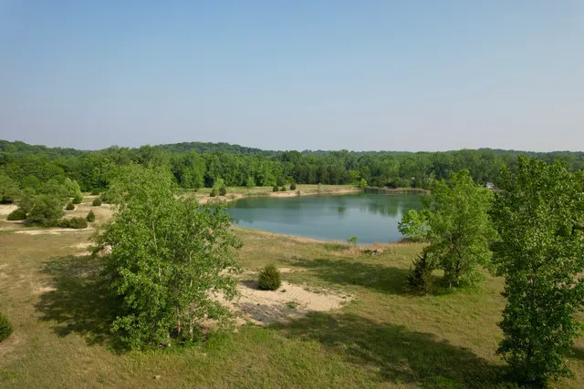 a view of a green field with a lake