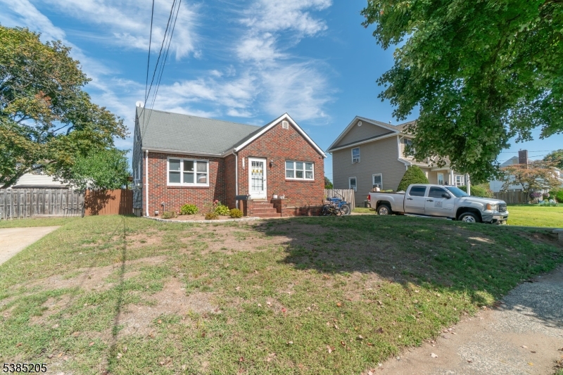 a front view of a house with a garden and trees