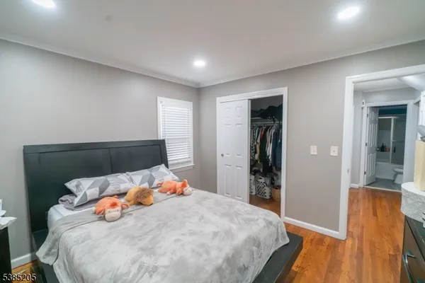 a bedroom with bed and wooden floor