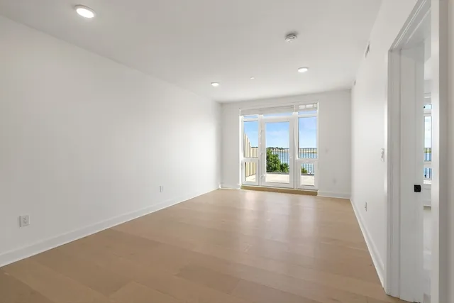 a view of a room with wooden floor and a window