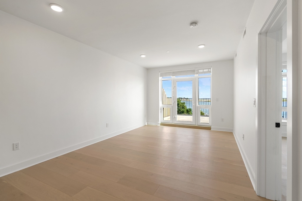 917 Bennington Street, Unit PH506 Boston, MA 02128 - Photo 3 of 11 a view of a room with wooden floor and a window