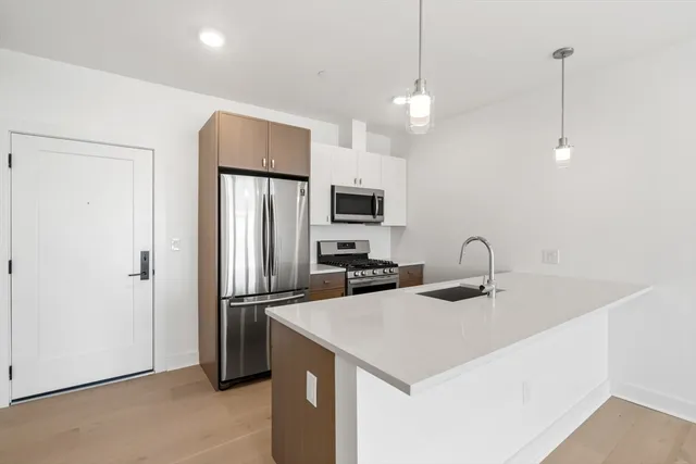 a kitchen with stainless steel appliances a refrigerator sink and microwave