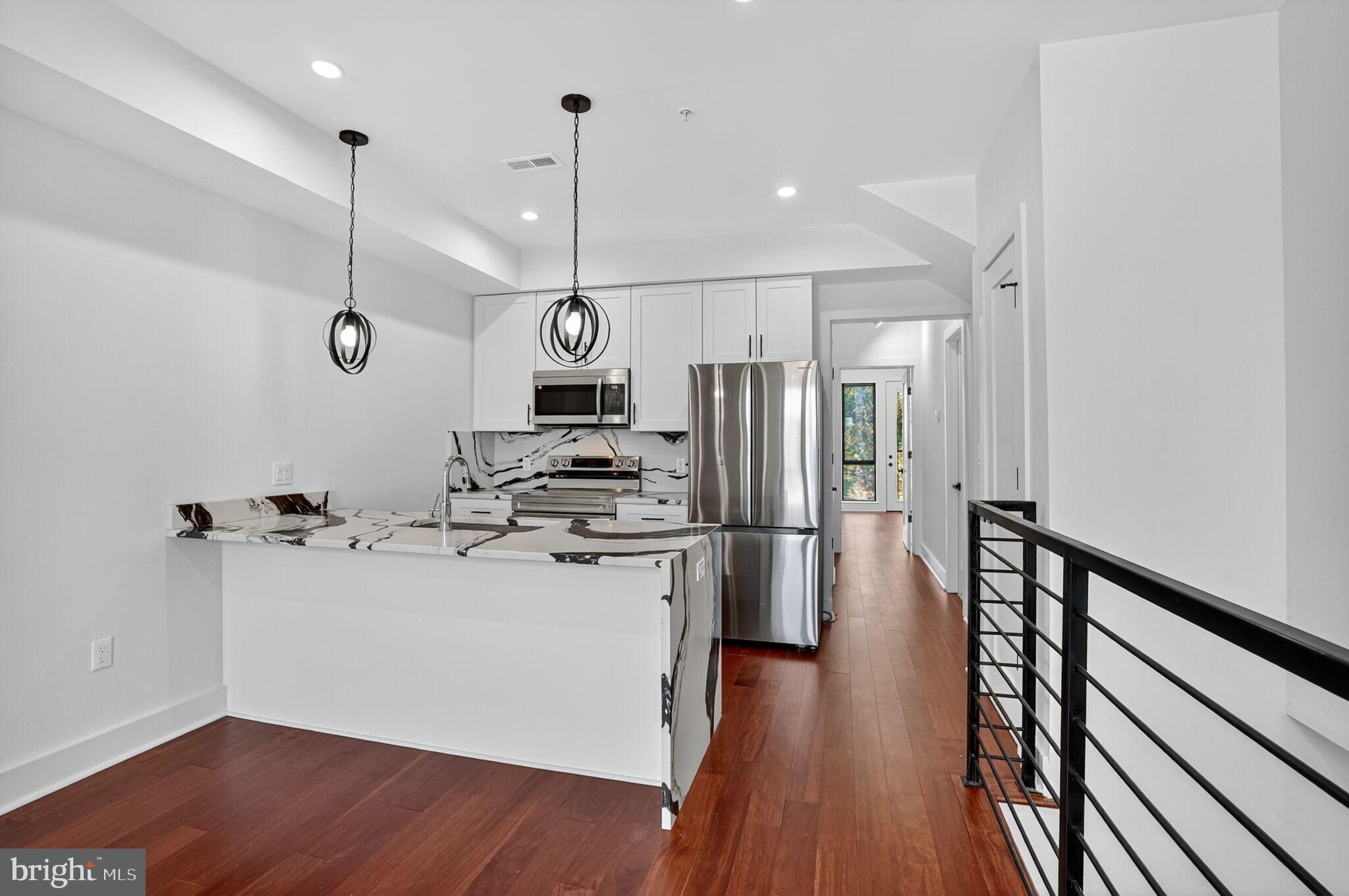 7319 Georgia Avenue Northwest Washington, DC 20012 - Photo 23 of 39 Sleek modern kitchen with warm wood accents.