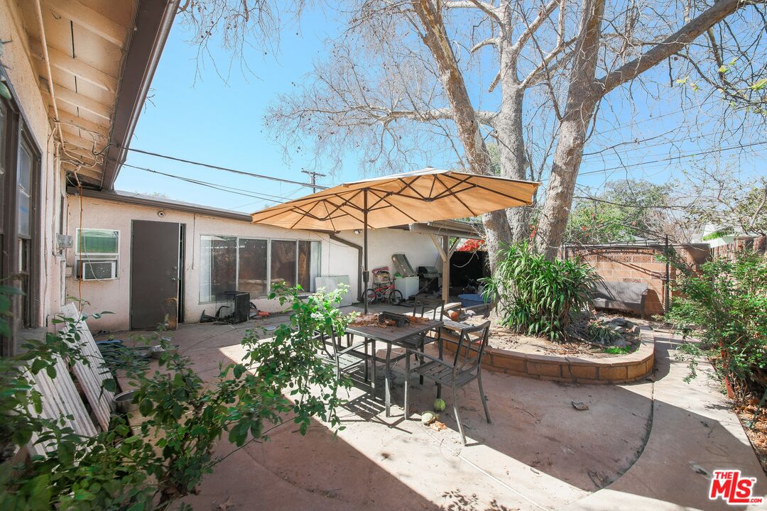 5663 Kester Avenue Van Nuys, CA 91411 - Photo 7 of 15 a view of a patio with table and chairs under an umbrella