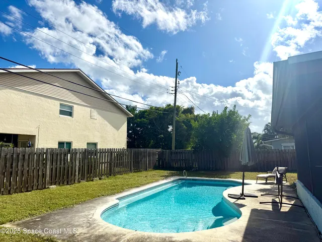 a view of a backyard with swimming pool