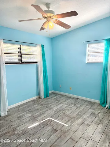 a view of room with a ceiling fan and wooden floor